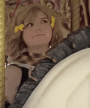 a woman with a yellow flower in her hair is sitting in a chair