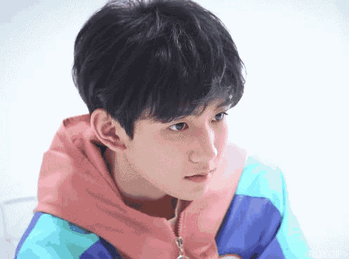 a close up of a young man wearing a colorful jacket