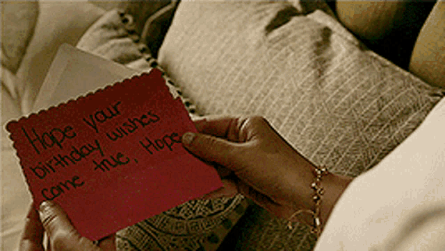 a person is holding a red card that says hope your birthday wishes come true hope