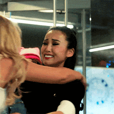 a woman hugging another woman who is crying
