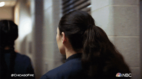 a woman with a ponytail is standing in a hallway with the hashtag #chicagofire