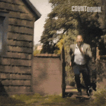 a man running in front of a building with the word countdown on the bottom