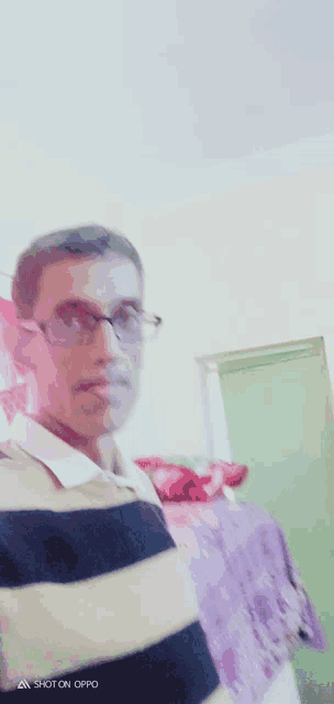 a man wearing glasses and a striped shirt has a shot on oppo on the bottom left