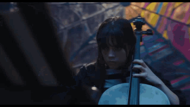 a woman playing a cello with a stained glass window in the background