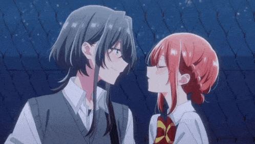 a boy and a girl are kissing each other on the cheek .