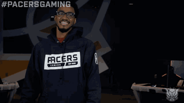 a man wearing a pacers gaming sweatshirt smiles for the camera