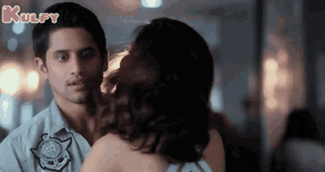 a man and a woman are kissing and the words kulfy are visible on the bottom