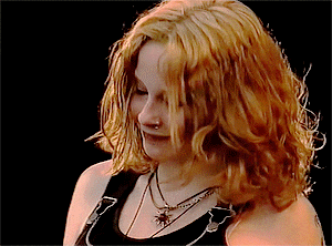 a woman with red hair and a nose ring is wearing a black tank top