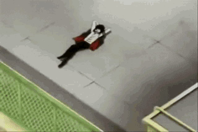 a person is laying on the ground with their arms outstretched .