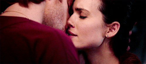 a man and a woman are kissing each other on the forehead .