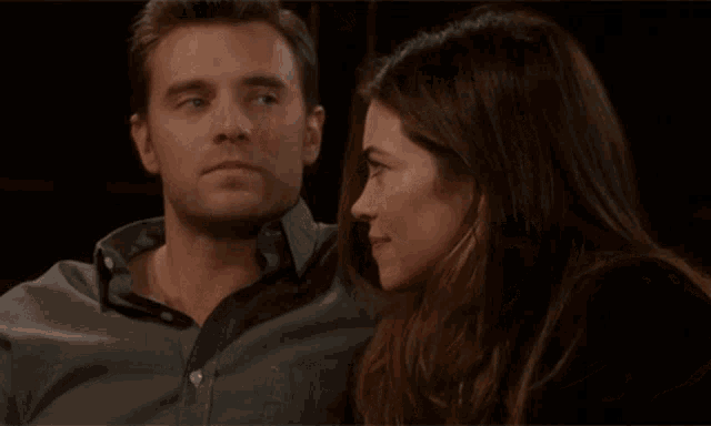 a man kisses a woman on the forehead while the woman looks on