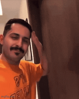 a man with a mustache is wearing an orange shirt that says ' 21 ' on it