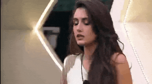 a woman with long dark hair is wearing a white shirt and a necklace .