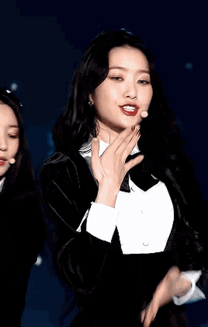 a woman in a tuxedo covers her face with her hands