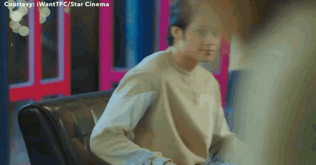 a man is sitting on a couch with the words courtesy i wantfc / star cinema on the bottom