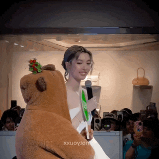 a woman in a white dress holds a fan next to a stuffed bear