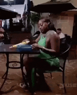 a woman is sitting at a table eating food .