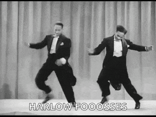 a couple of men in tuxedos are dancing on a stage .