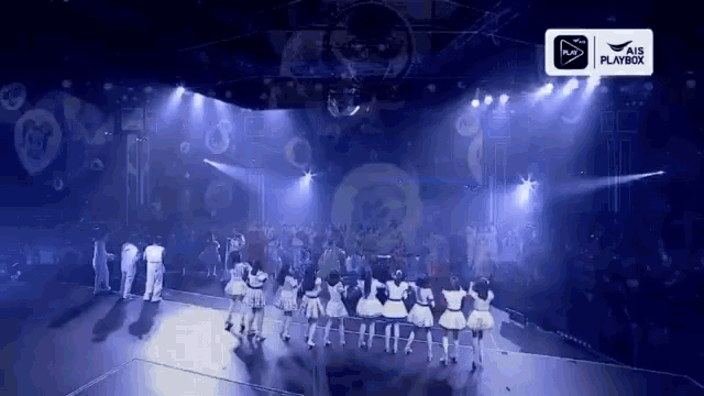 a group of people are dancing on a stage in front of a sign that says air playboy