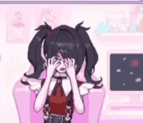a girl with pigtails is sitting in a chair with her hands on her face .