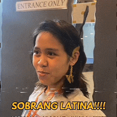 a woman in front of a sign that says entrance only and sobrang latina