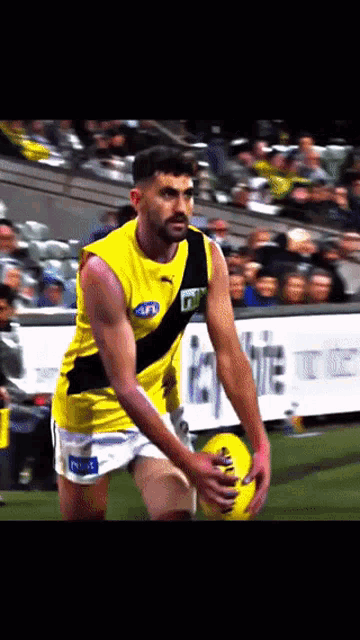 a man in a yellow tank top with a black stripe that says tnt