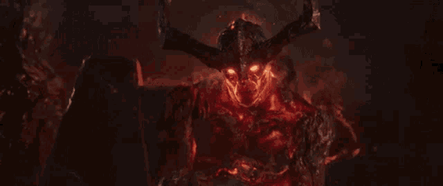 a demon with horns and red eyes is standing in the dark .