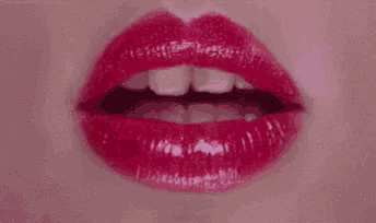 a close up of a woman 's lips with red lipstick on .