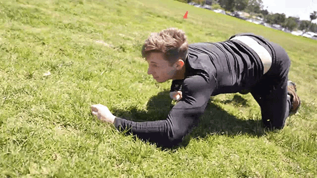 a man is doing a plank exercise in the grass .