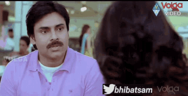 a man in a pink shirt is talking to a woman in a video sponsored by volga