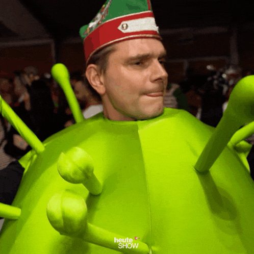 a man in a green costume with the words heute show on it
