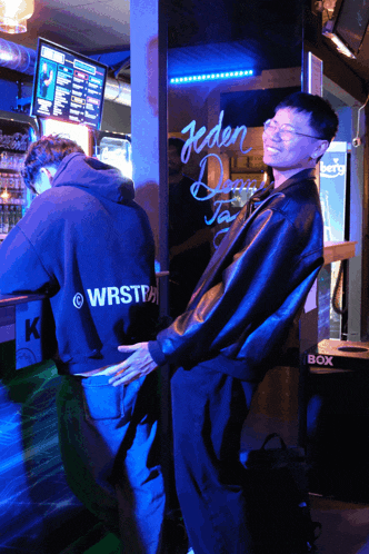two men standing in front of a sign that says jeden dan