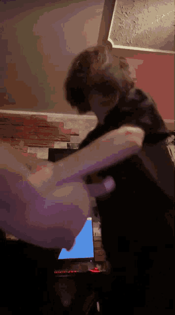 a blurry picture of two people fighting in front of a computer screen