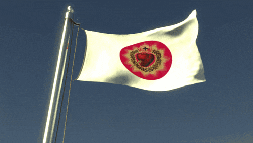 a white flag with a red heart in the center is waving in the wind