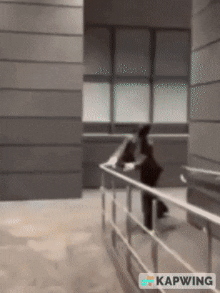 a blurred image of a person walking down a staircase with the caption kapwing