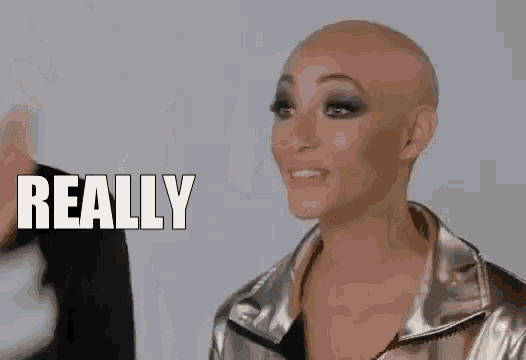 a woman with a bald head is wearing a silver jacket and making a face .
