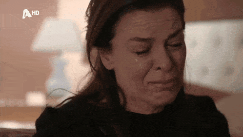 a woman is crying with a tear coming out of her eye .