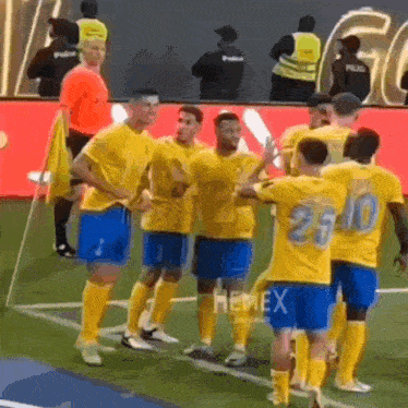 a group of soccer players are standing on a field and one has the number 25 on his jersey