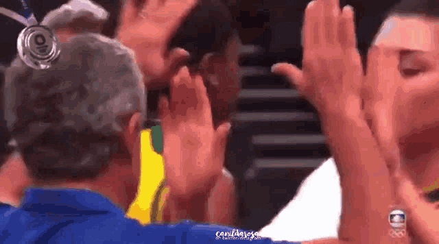 a group of people are giving each other a high five while wearing a medal .