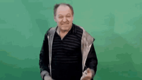 a man in a striped shirt and jacket is giving a thumbs up .