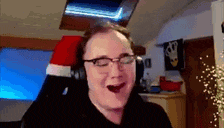 a man wearing glasses and headphones is making a funny face while sitting in a chair .