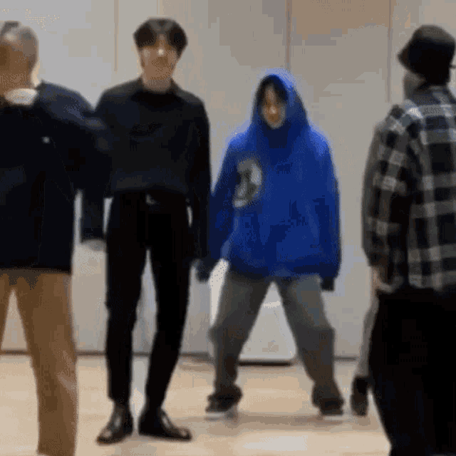 a group of people are standing next to each other on a wooden floor .