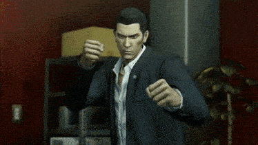 a man in a suit and white shirt is holding his fist up and saying `` let 's go '' .