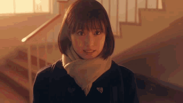 a girl wearing a scarf and a jacket with the letter a on the front