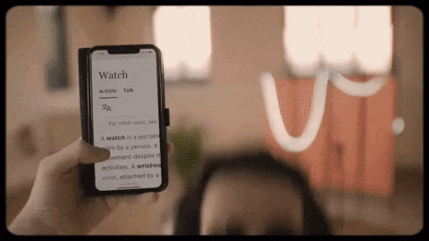 a person is holding a phone that says watch on the screen