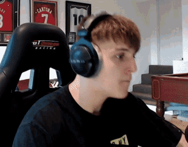 a young man wearing headphones is sitting in front of a pool table ..