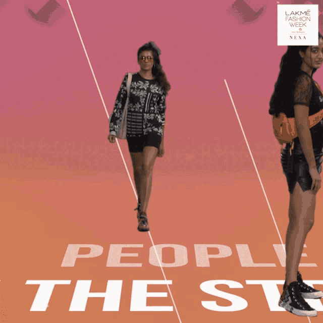 a woman walks down a runway in front of the word people