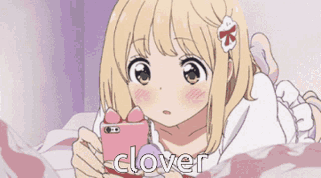 a girl is laying on a bed looking at her phone and the word clover is visible
