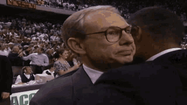 a man in a suit and tie is talking to another man