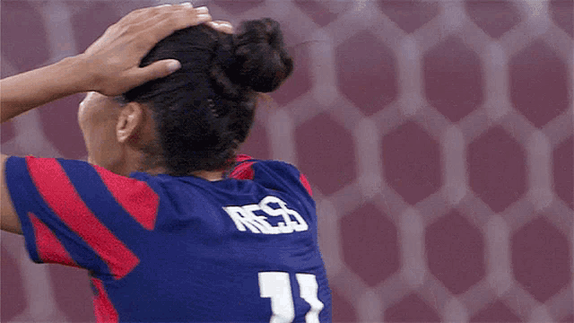 a female soccer player wearing a jersey with the number 11 on it